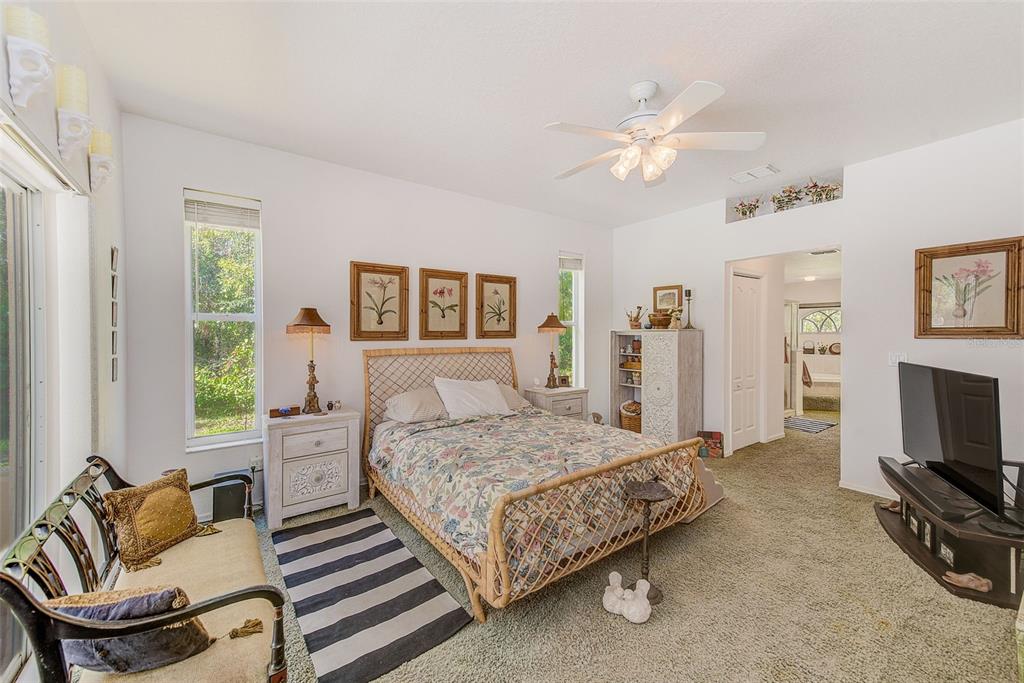 4 Poppy Court Homosassa, FL 34446 - Photo 23 of 55 a bedroom with a bed a couch and a chandelier