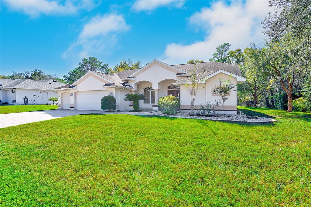 4 Poppy Court Homosassa, FL 34446 - Photo 3 of 55 a front view of a house with a garden and yard