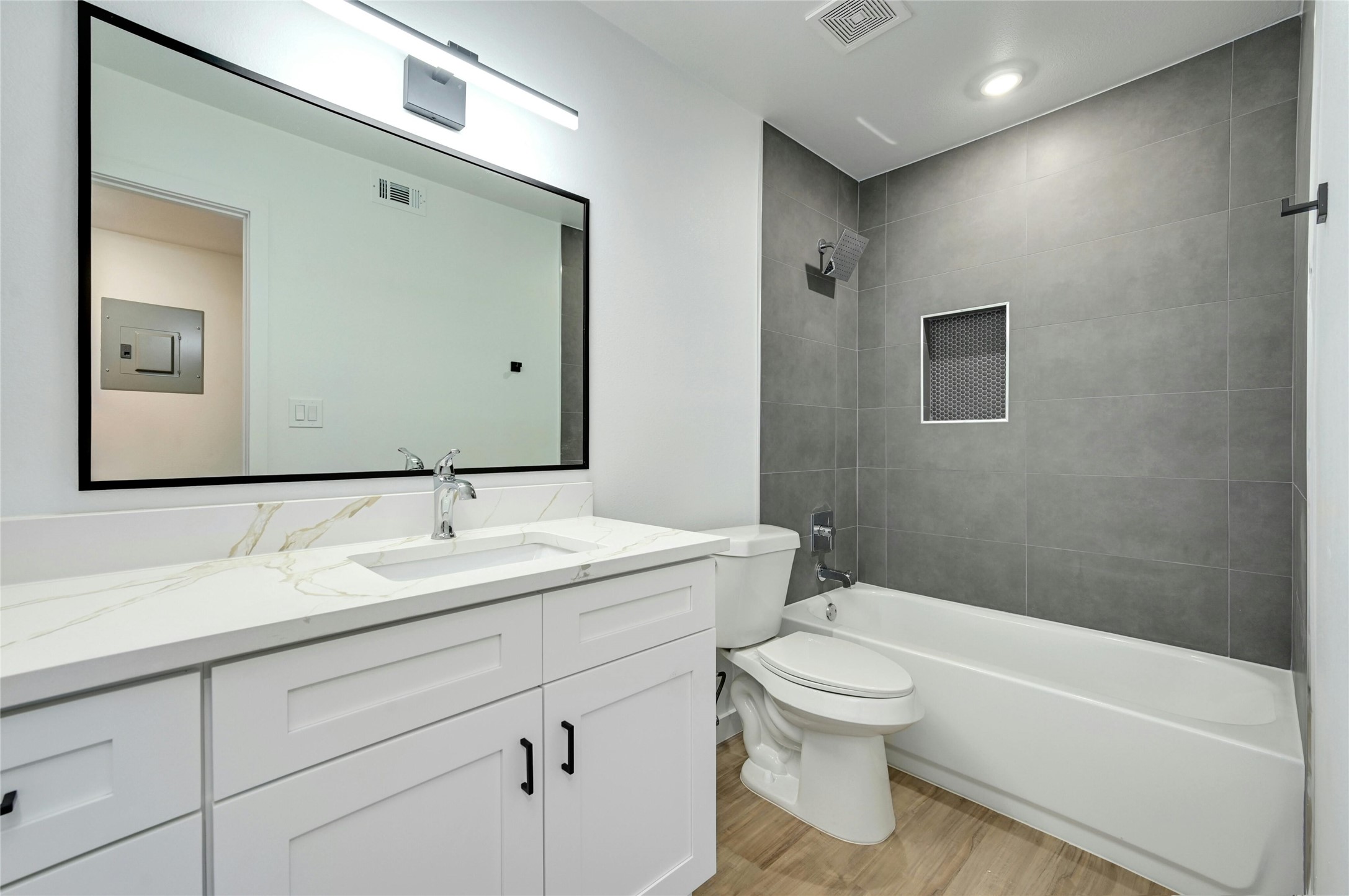 202 East 45th Street, Unit 103 Austin, TX 78751 - Photo 18 of 27 a bathroom with a toilet a sink a mirror and a bathtub