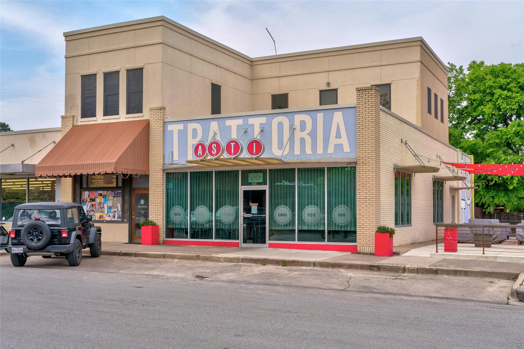 202 East 45th Street, Unit 103 Austin, TX 78751 - Photo 21 of 27 a view of a brick building with a large window and a parked car