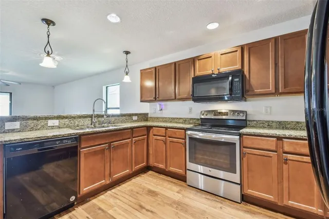 a kitchen with stainless steel appliances granite countertop a stove sink and microwave