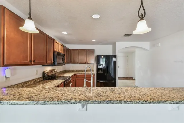 a view of a refrigerator in kitchen and a wooden floor