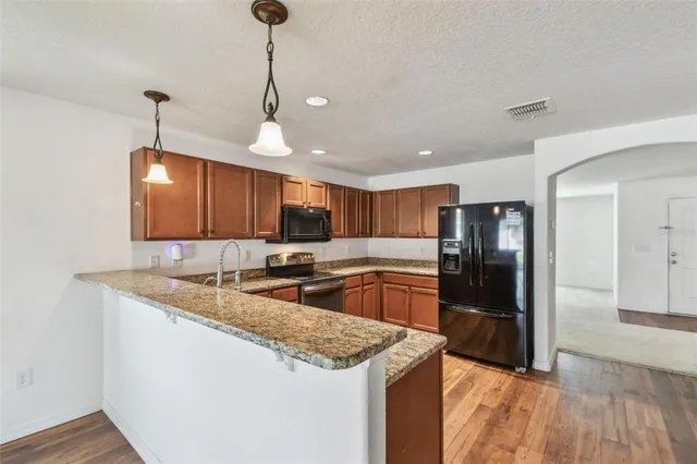 a view of a kitchen with wooden floor and a ceiling fan