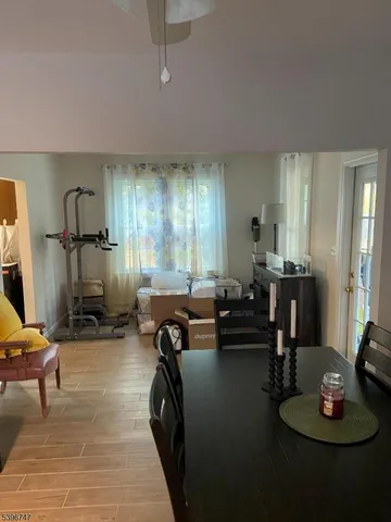 a living room with furniture a chandelier and a flat screen tv