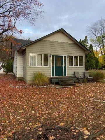 a front view of house with yard and trees around