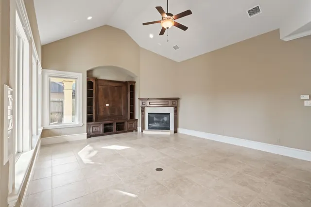 a view of an empty room with a fireplace and a window