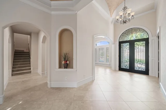 a view of a hallway with windows and chandelier