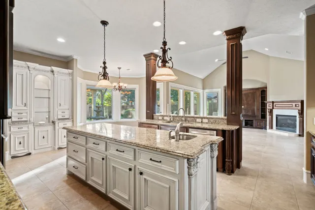 a kitchen with granite countertop a sink stove and refrigerator