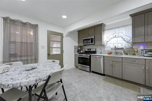 a kitchen with granite countertop a sink appliances and cabinets