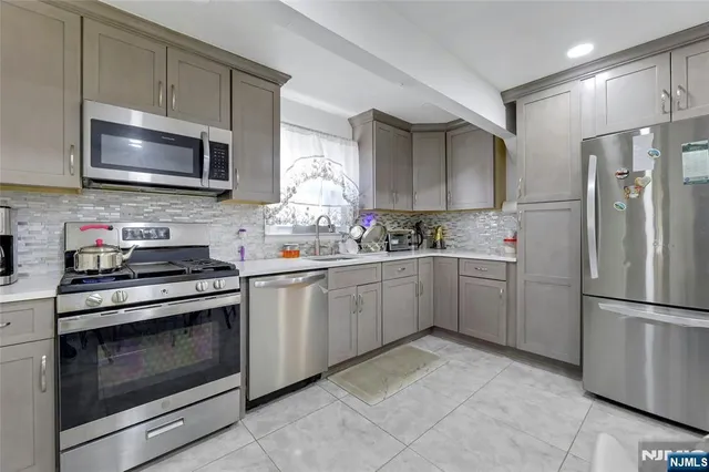 a kitchen with stainless steel appliances granite countertop a stove a refrigerator and a microwave