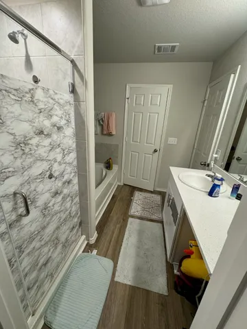 a bathroom with a sink a toilet and shower