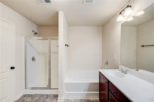 a bathroom with a sink vanity granite tub shower and a mirror