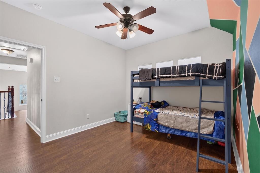 517 Austin Acre Road Sulphur Springs, TX 75482 - Photo 19 of 23 a bedroom with a bed and a chandelier