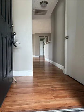 a view of a hallway view with wooden floor and staircase