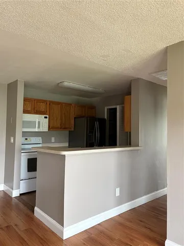a view of kitchen with stainless steel appliances cabinets and wooden floor