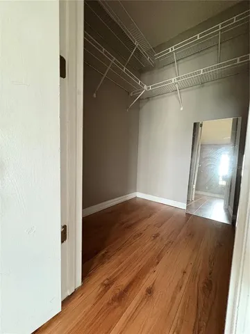 a view of empty room with wooden floor