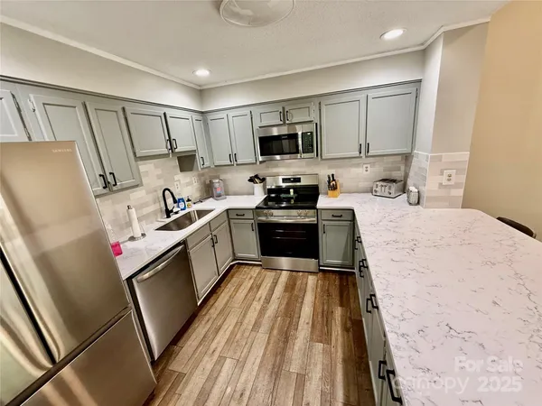 a kitchen with sink a microwave a refrigerator and cabinets