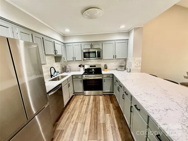 a kitchen with a sink a refrigerator a stove top oven and cabinets