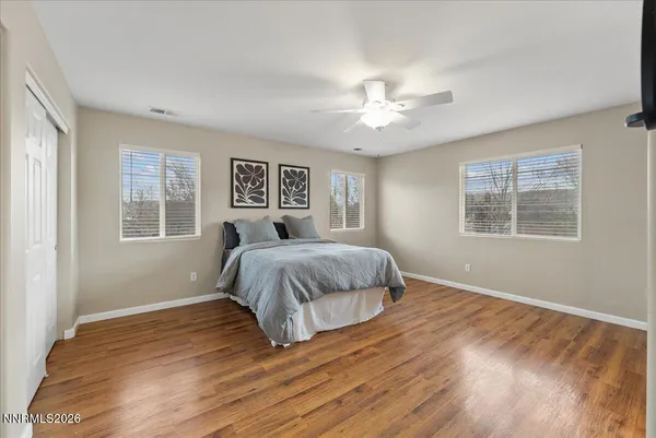 a spacious bedroom with a large bed chandelier and a window