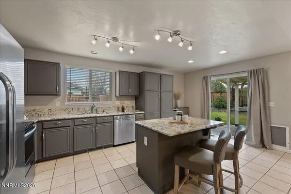 a kitchen with granite countertop a sink stainless steel appliances and white cabinets