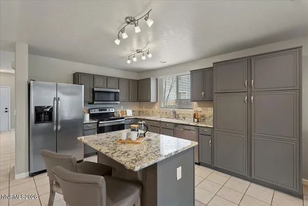 a kitchen with kitchen island granite countertop stainless steel appliances cabinets a sink and a center island