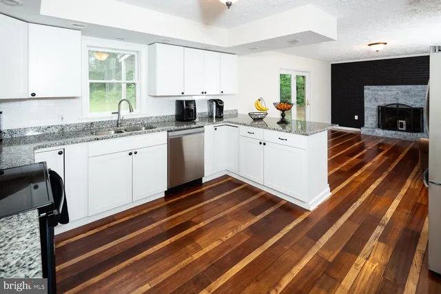 a kitchen with granite countertop a stove a sink and a microwave