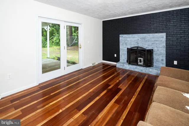 a living room with a balcony a fireplace and a table