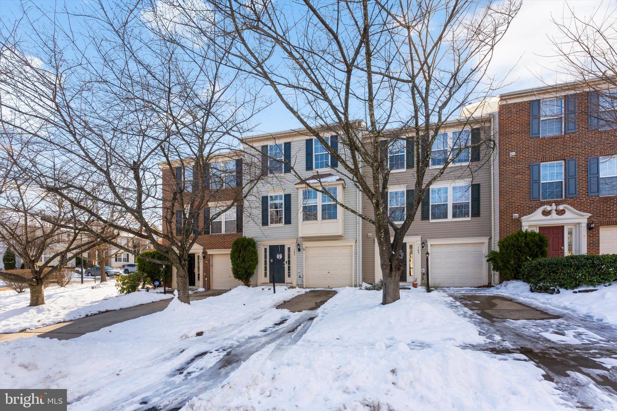163 Shirley Square Southeast Leesburg, VA 20175 - Photo 1 of 45 a front view of a house with a yard covered with snow