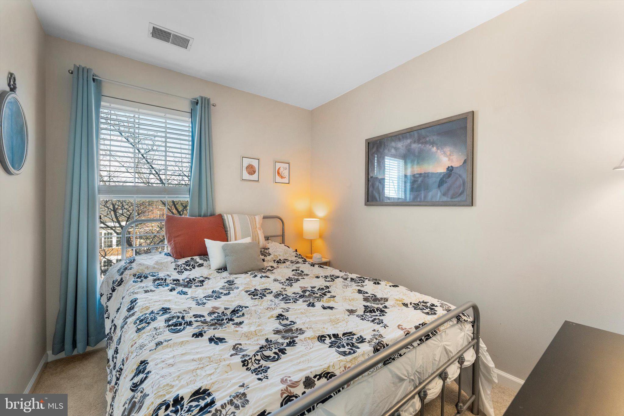 163 Shirley Square Southeast Leesburg, VA 20175 - Photo 30 of 45 a bedroom with a bed and wooden floor