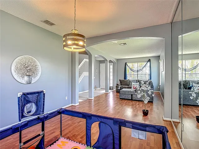 a kitchen with stainless steel appliances kitchen island granite countertop a refrigerator a stove top oven a sink dishwasher and dining table with wooden floor