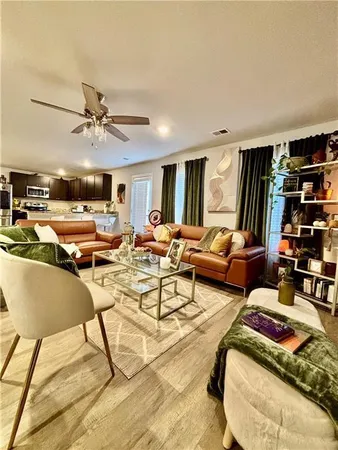 a living room with lots of furniture and kitchen view