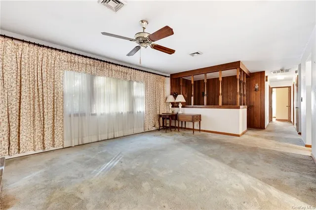 a view of a livingroom with a ceiling fan & entryway