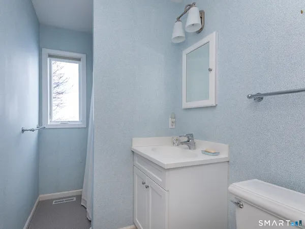 a bathroom with a sink a toilet and a mirror