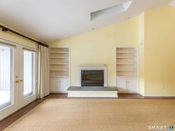 a view of an empty room with a fireplace and a window