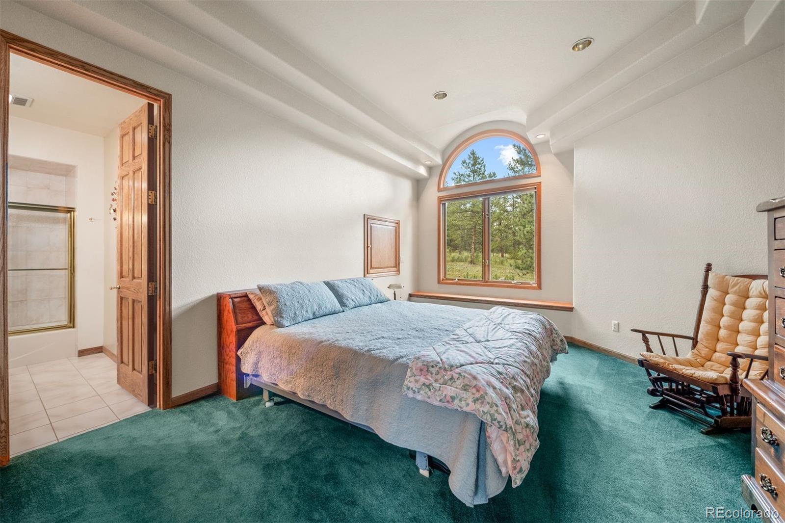 21206 Spring Creek Road Sedalia, CO 80135 - Photo 26 of 50 a bedroom with a bed and window