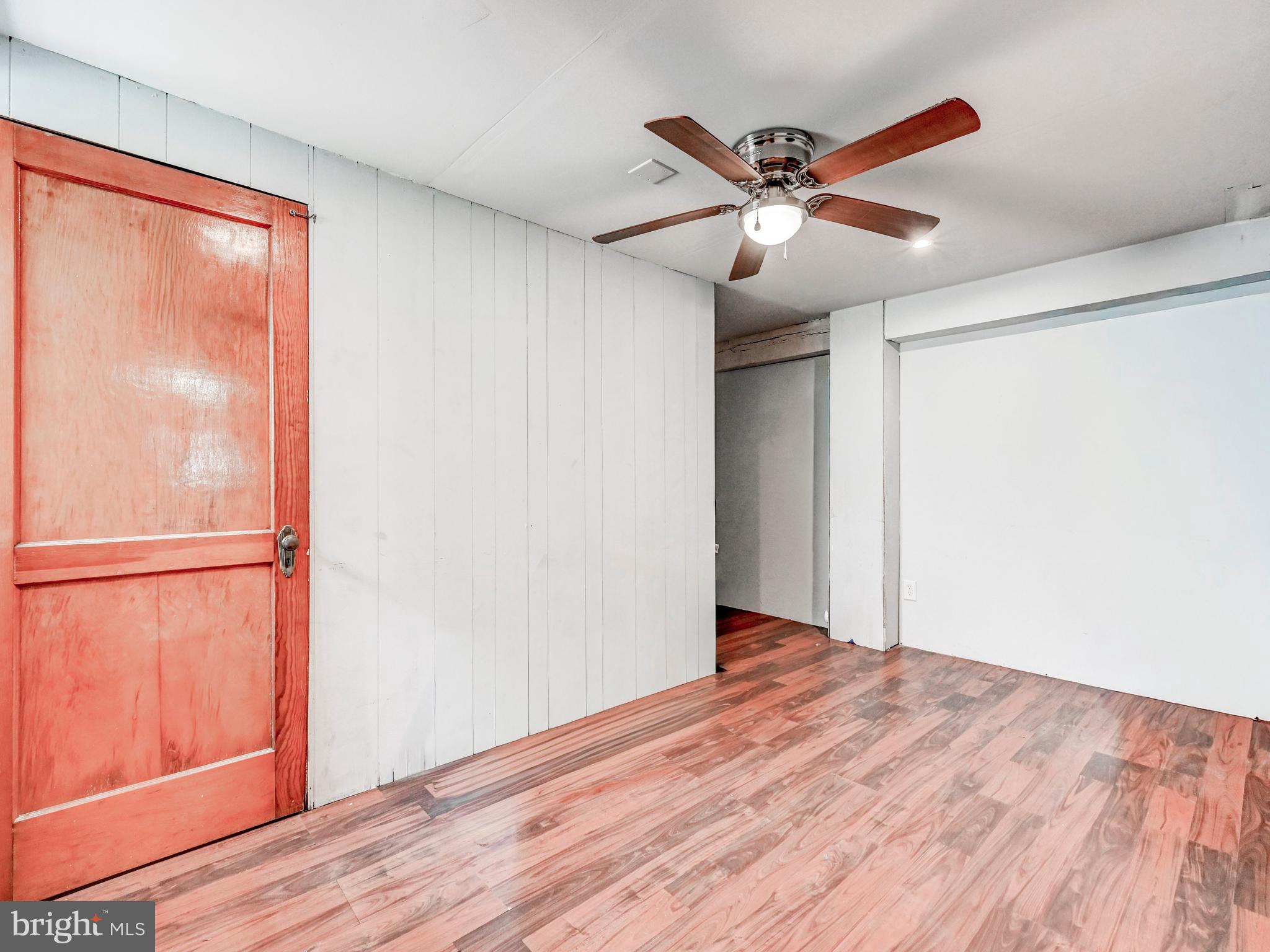 3206 Lynch Road Baltimore, MD 21219 - Photo 32 of 70 a view of an empty room with wooden floor and a ceiling fan