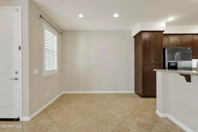 a view of a hallway with stainless steel appliances