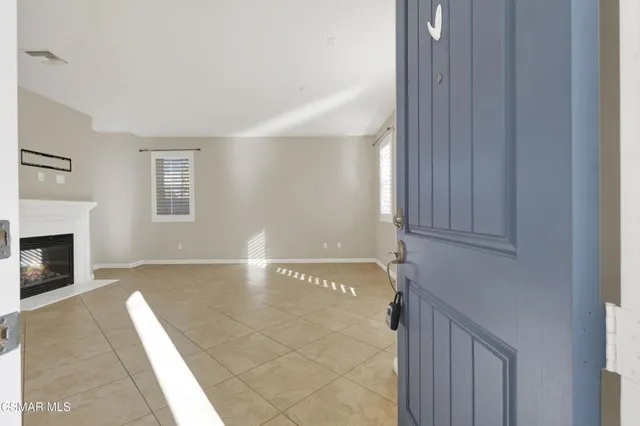 a view of an empty room with a fireplace and a window