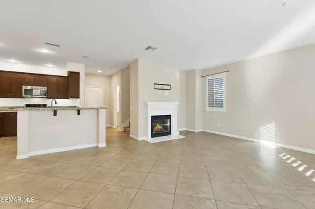 a view of a kitchen with an empty space and a fireplace