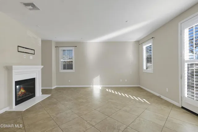 a view of an empty room with window and fireplace