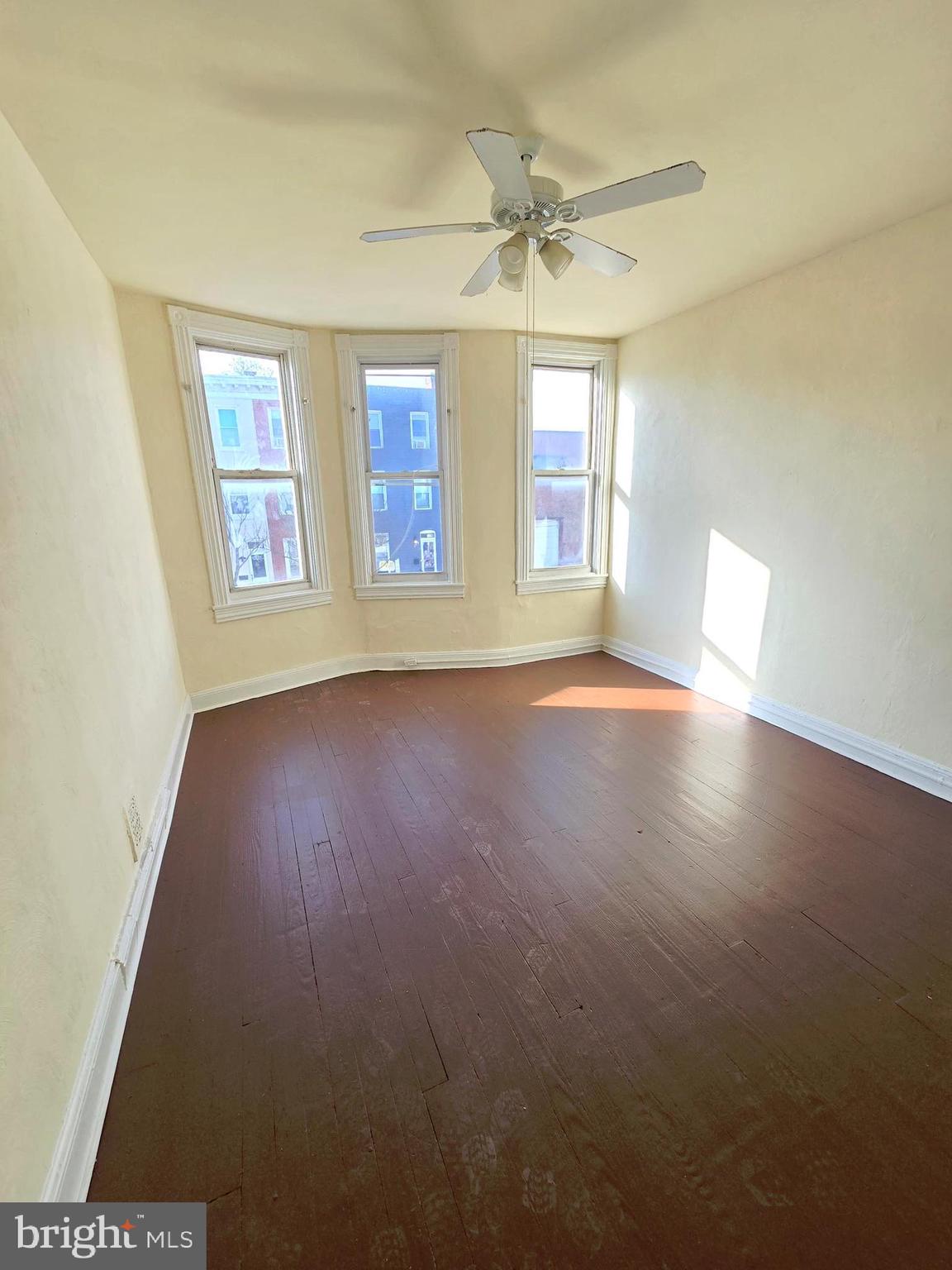 321 South Mount Street Baltimore, MD 21223 - Photo 10 of 20 an empty room with wooden floor and windows