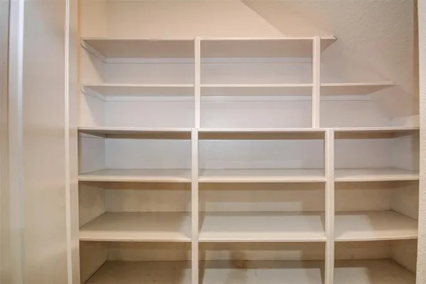 a view of walk in closet with empty racks