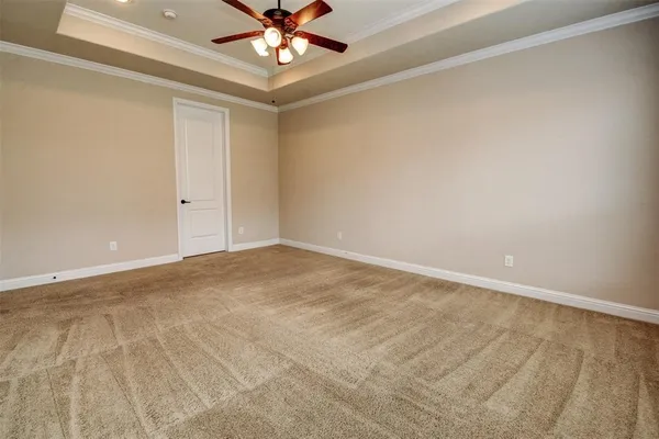 a view of an empty room and chandelier fan