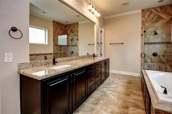 a bathroom with a granite countertop sink a mirror a bathtub and shower