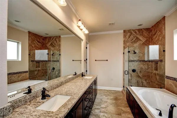 a bathroom with a granite countertop tub sink and mirror