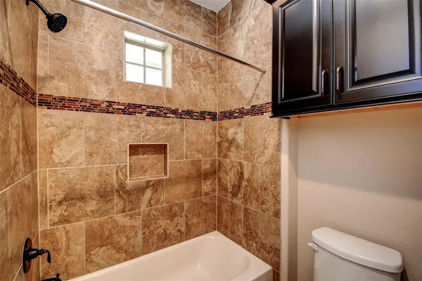 a bathroom with a shower a toilet and a sink