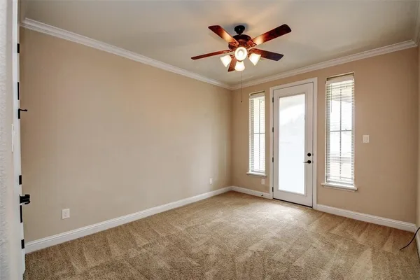 an empty room with windows and chandelier fan