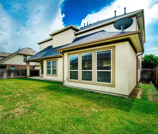 a view of an house with backyard space and balcony