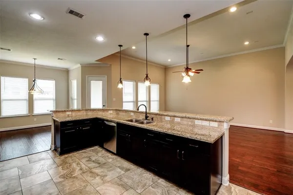 a kitchen with a sink a counter space appliances and windows