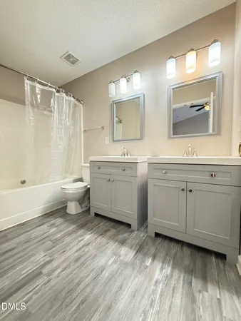 a bathroom with a toilet sink double vanity and mirror